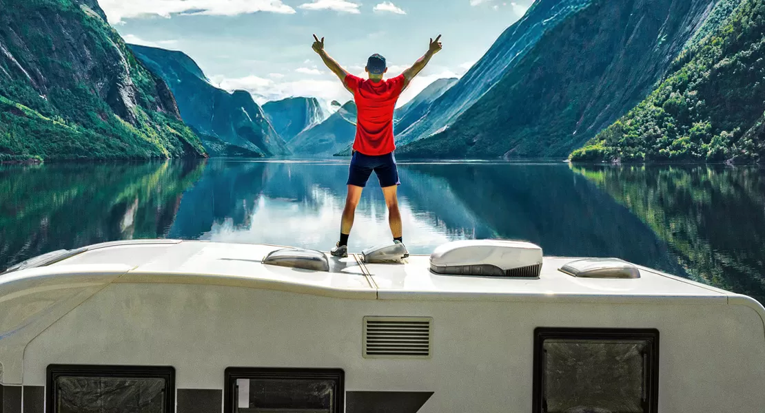 Man standing on RV by lake